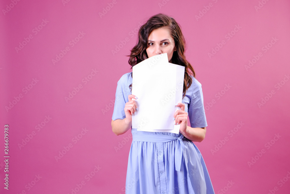 Young caucasian woman holding paper over pink background scared in shock with a surprise face, afraid and excited with fear expression Young caucasian woman holding paper over pink background scared in shock with a surprise face, afraid and excited with fear expression