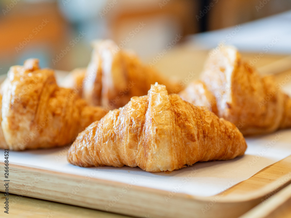 Croissant close up on wooden plate Croissant close up on wooden plate