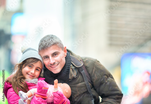 Father and daugher happy on a New York City holiday. Light rays coming from the sky © jovannig