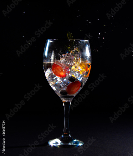 Glass with ice, fruit and drops of splash