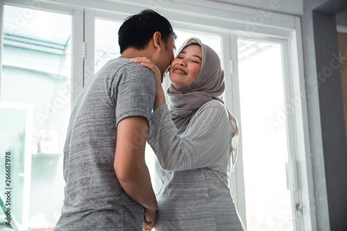 husband and wife muslim kissing each other at home © Odua Images