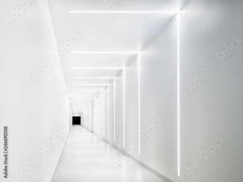 Empty white tunnel with a dark exit at the end.