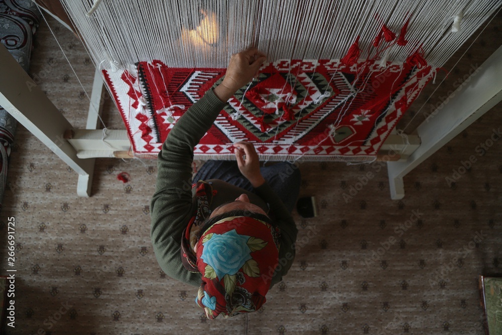 Obraz premium Woman hands weaving a handmade carpet .Kayseri/Turkey