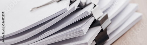 panoramic shot of stacks of blank paper with metal paper clips