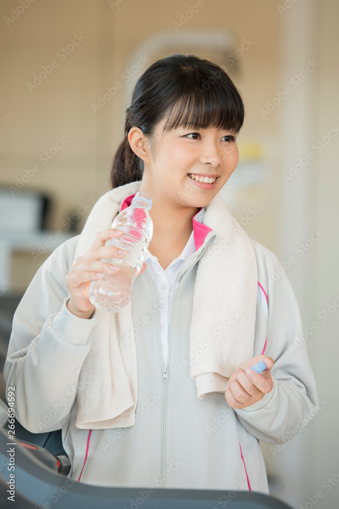 ジムで水分補給をする女性