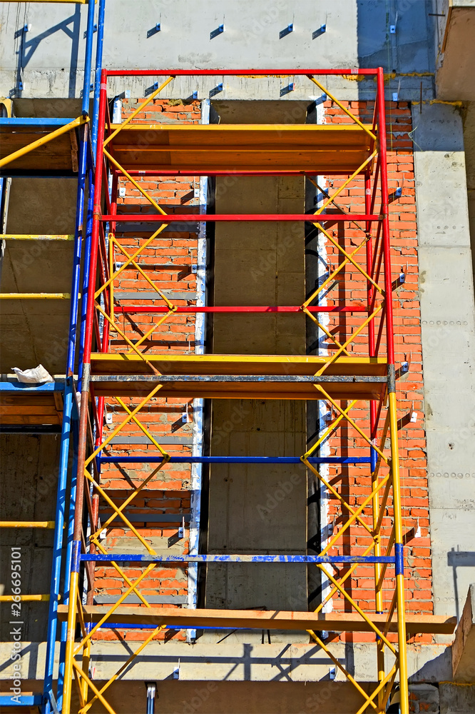 colorful scaffolding in sunny day, building site diversity