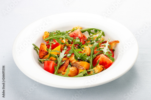 Salad with anchovies and sweet pepper, with croutons and arugula. On white background