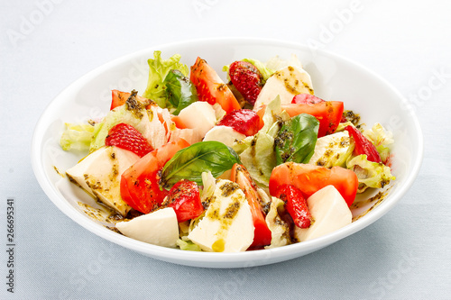 Caprese salad with strawberries. Salad with mozzarella, tomatoes, Basil and strawberries. On white background