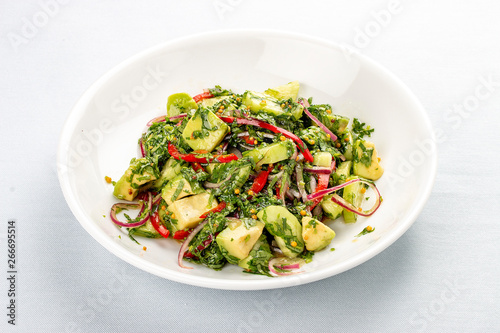 Salad with avocado, sweet pepper and pesto. On white background
