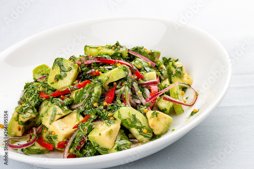 Salad with avocado, sweet pepper and pesto. On white background