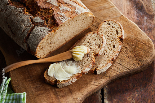 Photos Half buttered slice of rye bread with spreader