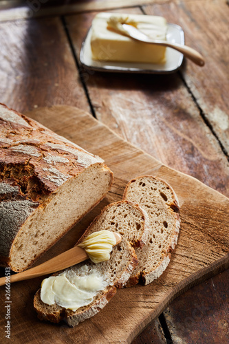 Sliced crusty loaf of fresh rye bread with butter