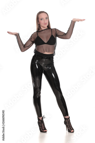 Young woman in black shiny leggings and net blouse on white background, holding imaginary object