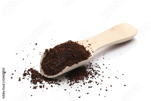 Milled coffee powder for espresso with wooden spoon isolated on white background