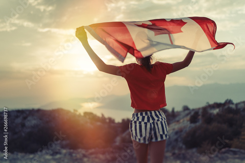 Photography Happy child teenage girl waving the flag of Canada while running at sunset