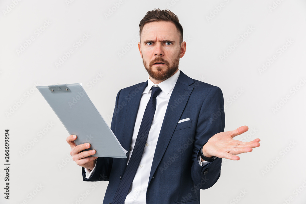 Confused businessman posing isolated over white wall background holding clipboard.