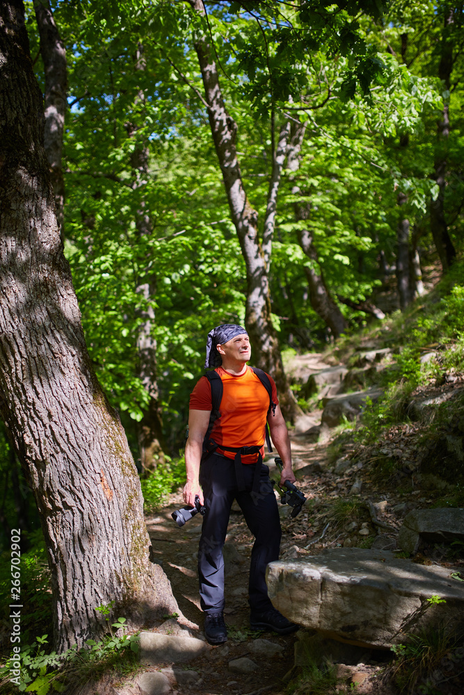 Hiker with camera in the forest Hiker with camera in the forest
