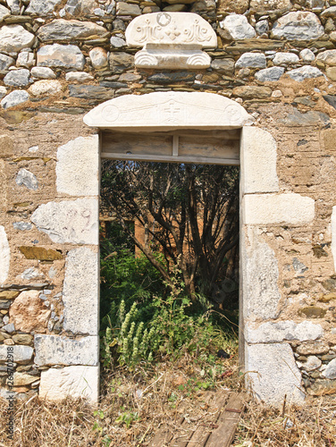 Wallpaper Mural Building detail of fallen door on stone wall in Mani Greece with sybols above door opening. Torontodigital.ca