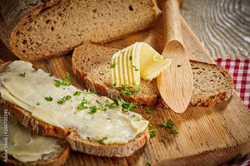 Buttered slices of fresh rye bread with parsley photo