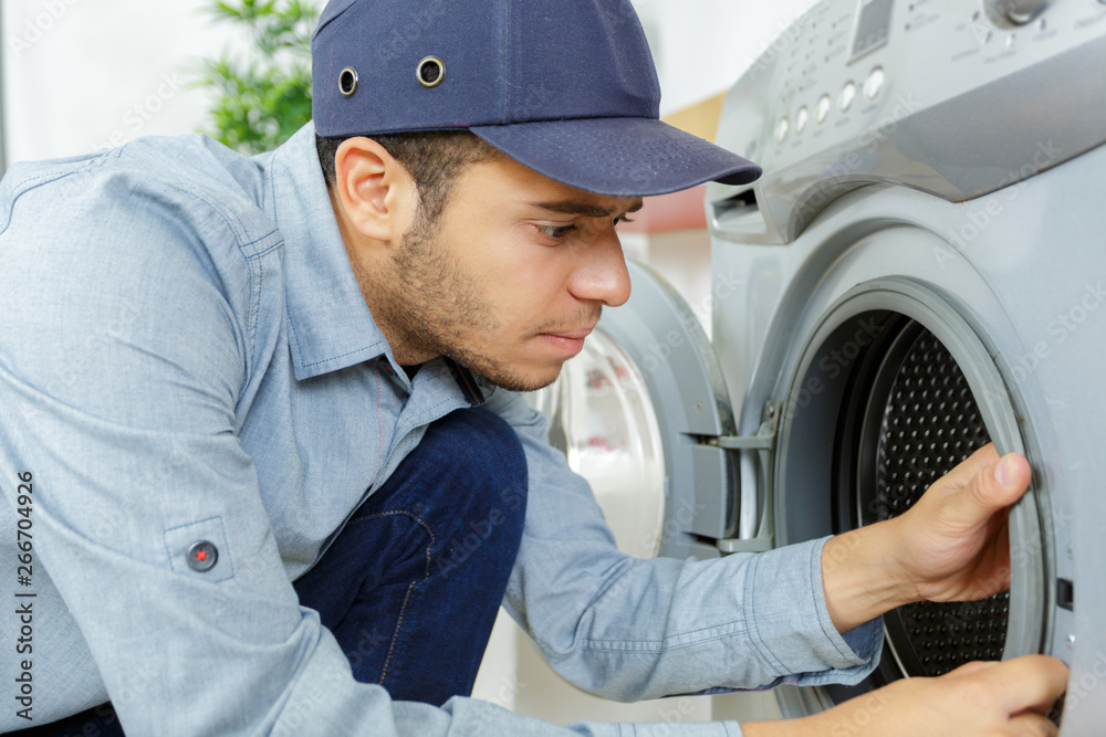 plumber with clipboard near washing machine plumber with clipboard near washing machine