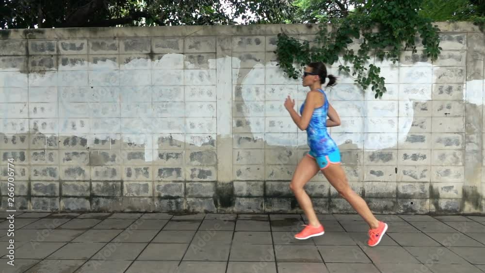 Young, fit sexy woman jogging in the city, super slow motion Young, fit sexy woman jogging in the city, super slow motion