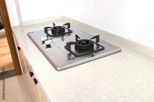 Cooking gas stove in modern kitchen, pantry with wood cabinets.