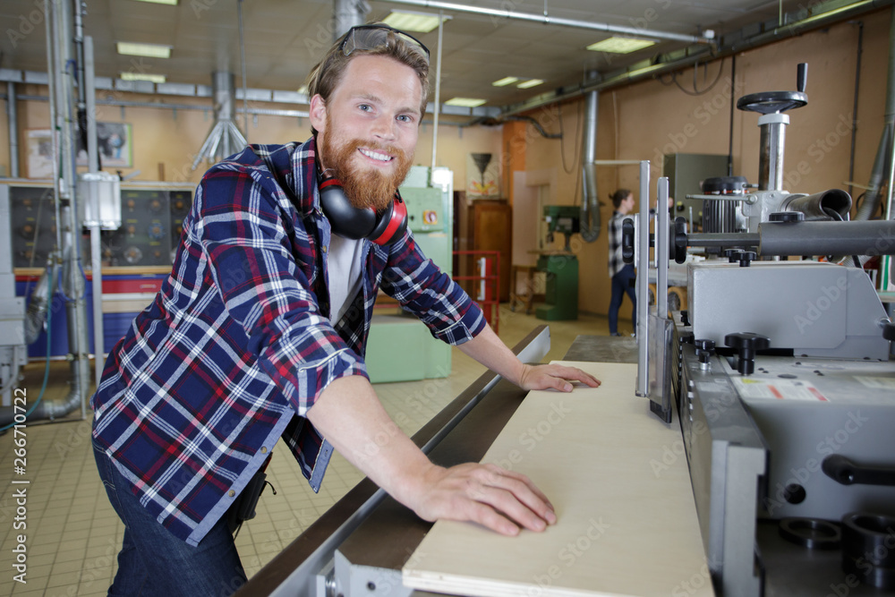 worker in a carpenters workshop using saw machine