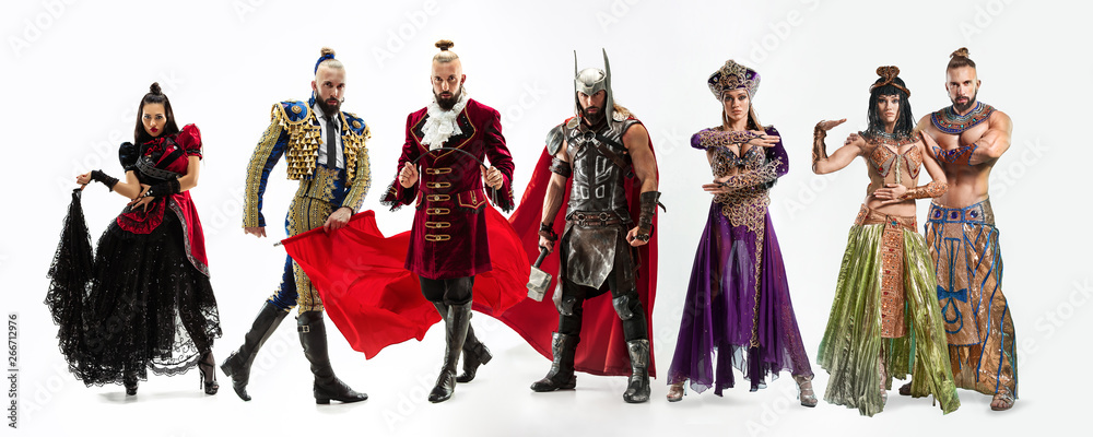 Bright fairy tale characters in costumes in front of white background. Toreador, scandinavian god of thunder and lightning, dancers, egyptian couple in traditional clothes. Creative collage.