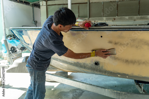 Wallpaper Mural Repairing boat body by puttying close up work after the accident by working sanding primer before painting. , The mechanic repair the boat  , Using plastic putty ,Prepare surface for boat, Torontodigital.ca