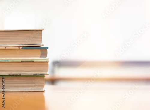 Book stack on wood desk in the library room and selective focus for business and  education background  back to school concept