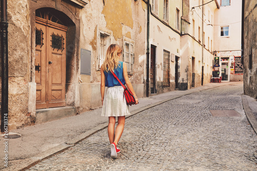 Cute attractive fashionable woman posing in the old European street. Fashion details.