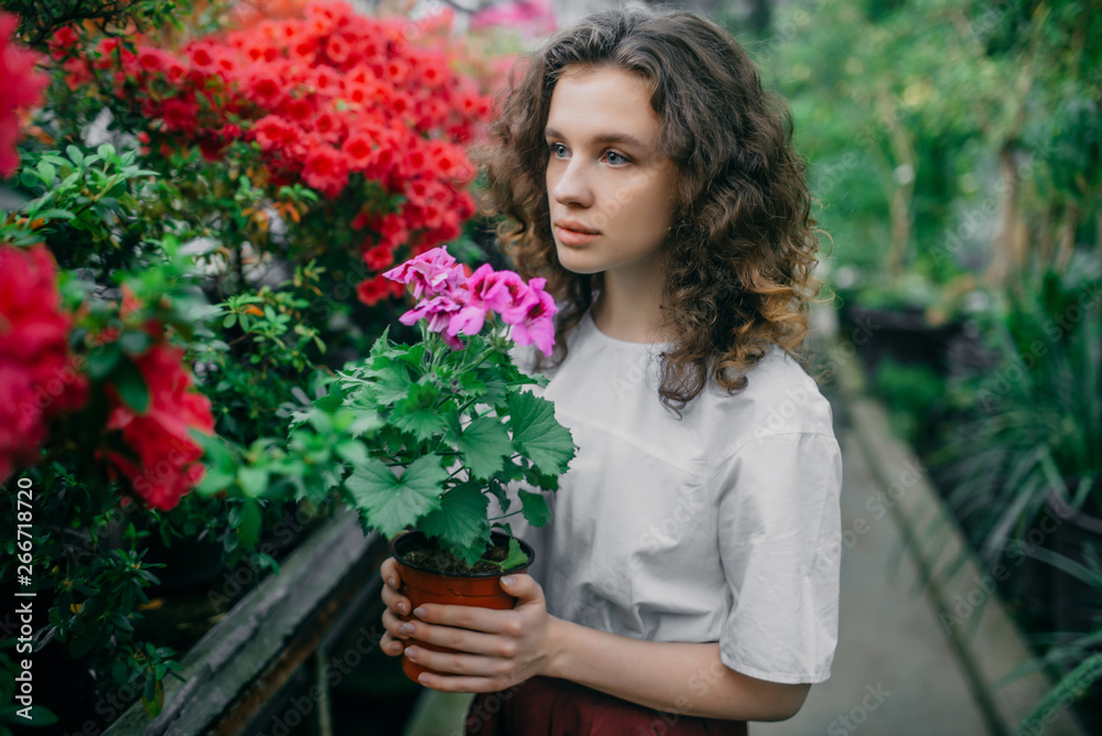 The young girl walks in a summer garden