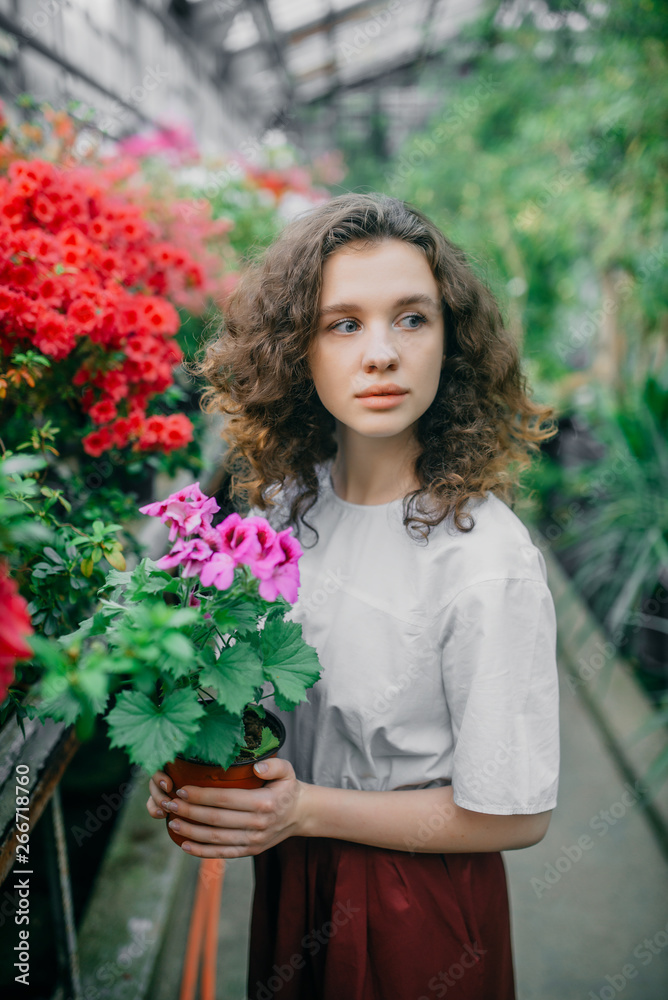 The young girl walks in a summer garden