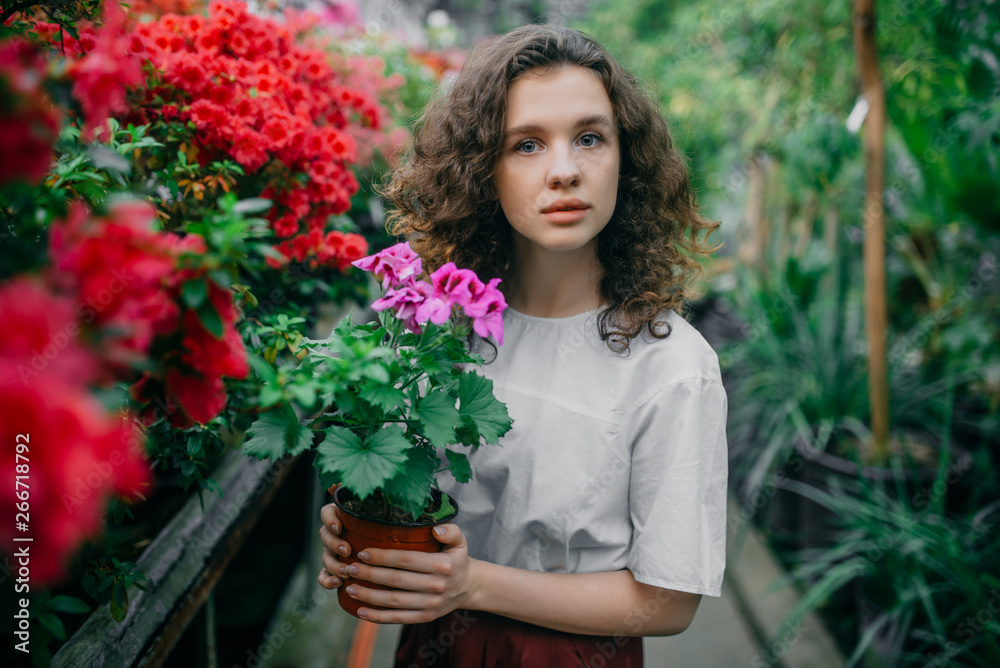 The young girl walks in a summer garden