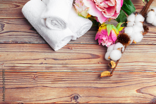 Cotton flowers with towel on wooden table