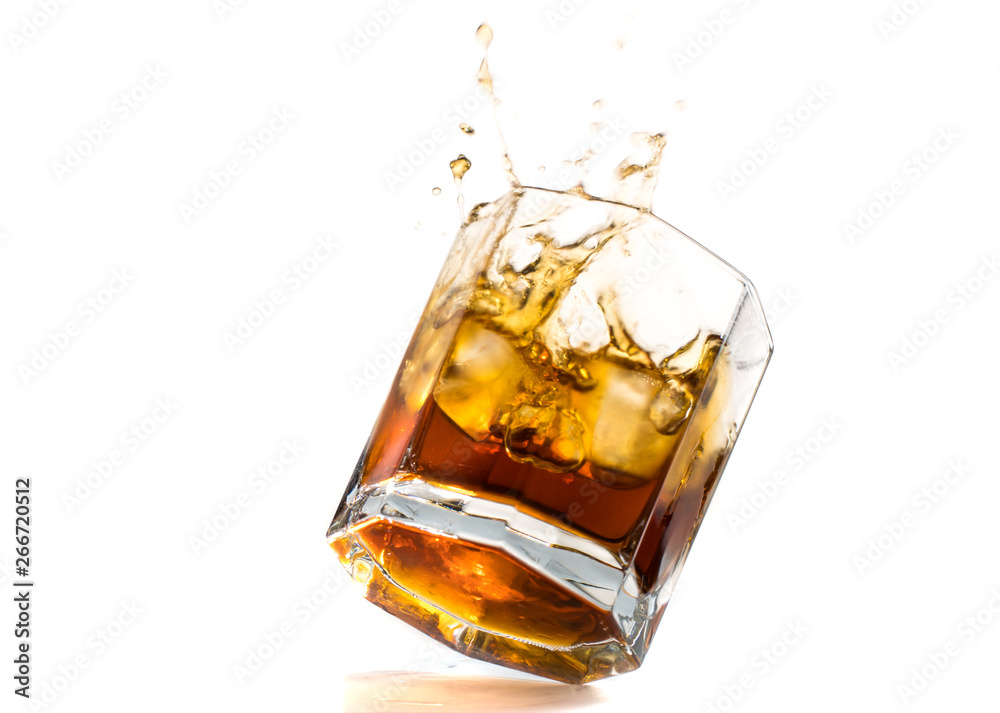 Fallen and falling whiskey glass with ice and splashes Fallen and falling whiskey glass with ice and splashes