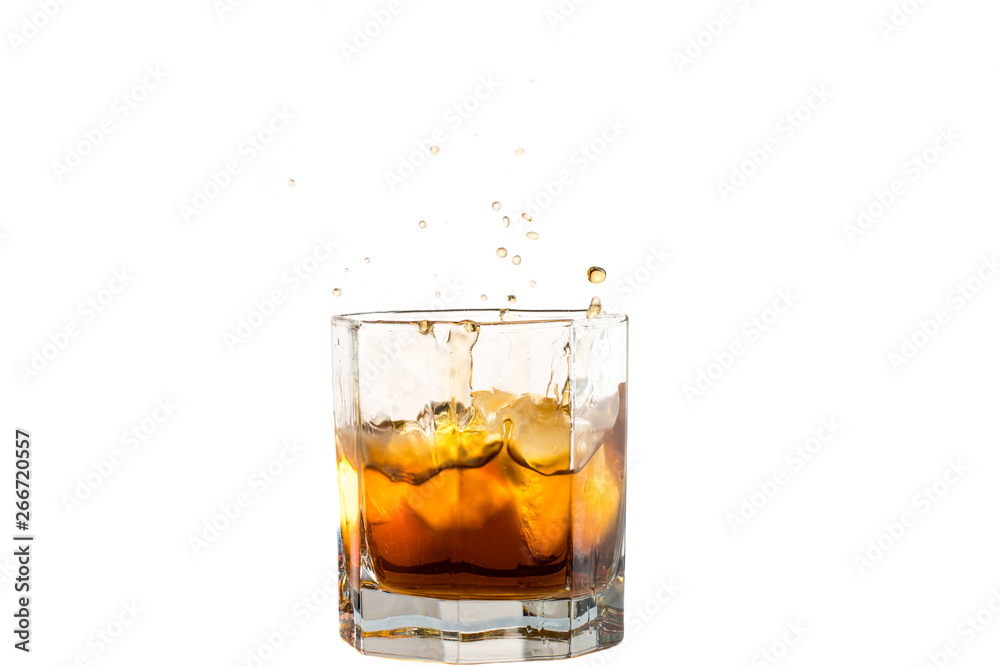 Fallen and falling whiskey glass with ice and splashes Fallen and falling whiskey glass with ice and splashes