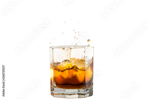 Fallen and falling whiskey glass with ice and splashes