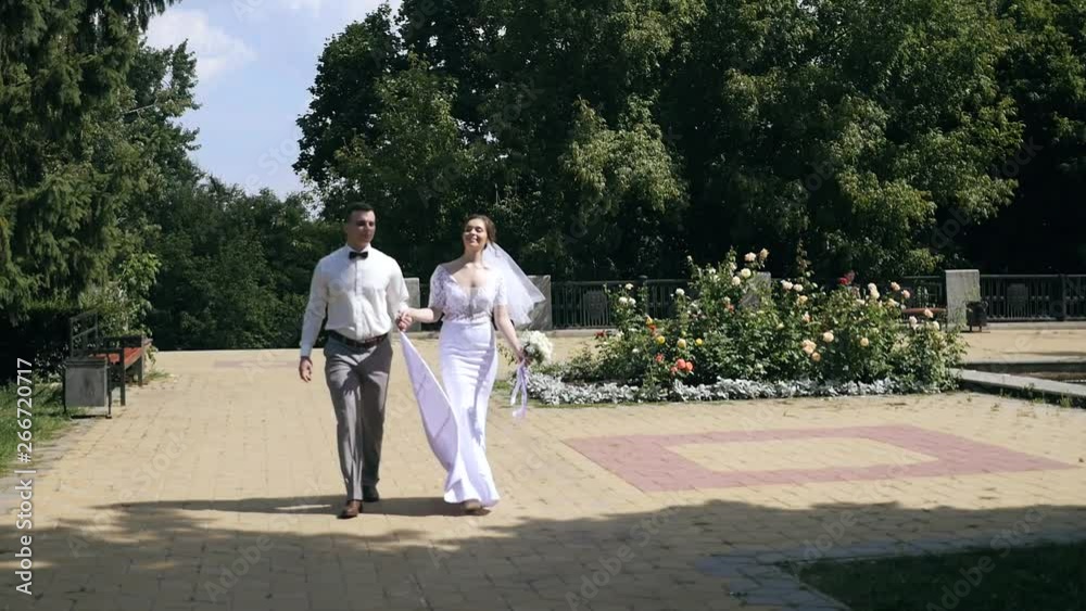 Happy wedding couple walking in the city park Happy wedding couple walking in the city park