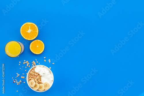 Bright breakfast with granola and orange juice on blue background top view mockup