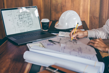 Construction engineering or architect hands working on blueprint inspection in workplace, while checking information drawing and sketching for architecture project working