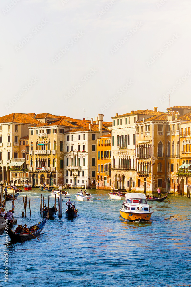 View of the Grand Canal with gondolas and colorful facades of old medieval houses from the Rialto Bridge in Venice, Italy. Venice is a popular tourist destination of Europe.