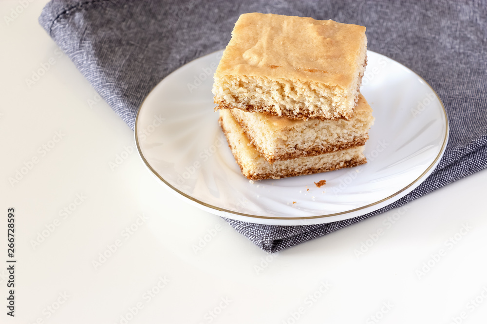 Stack of square pieces lemon shortcrust cake white background. Selective focus.