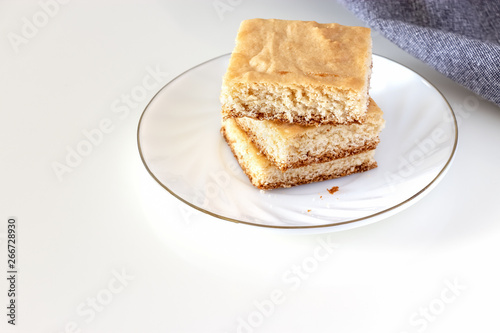 Stack of square pieces lemon shortcrust cake white background. Selective focus.