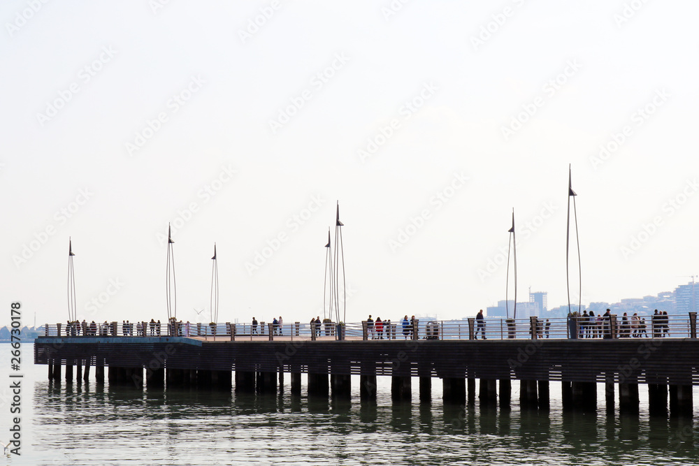 People on a wooden pier on the boulevard in Baku. Wooden pier in Baku.