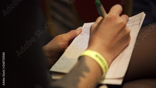 Close-up of woman hands taking notes in conference hall during business presentation. Art. Business meeting