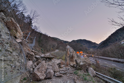 rockfall on the mainroad in dolomites area, northern Italy.  Big boalder on the road. danger zone photo