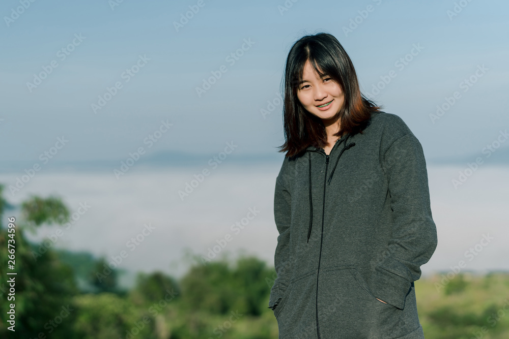 Asian woman Put on a smiling winter coat In the tourist area behind the fog and mountains with a smiling expression of happiness Asian woman Put on a smiling winter coat In the tourist area behind the fog and mountains with a smiling expression of happiness