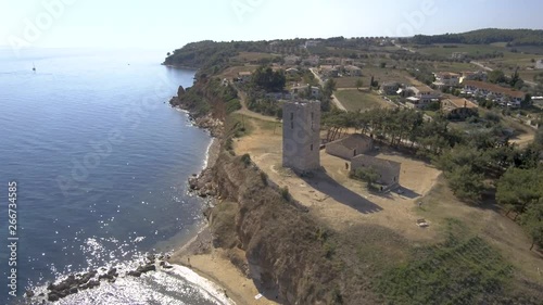 Aerial view of a medieval tower on the beach of Nea Fokea ,Halkidiki Greece,  move forward and down by drone photo