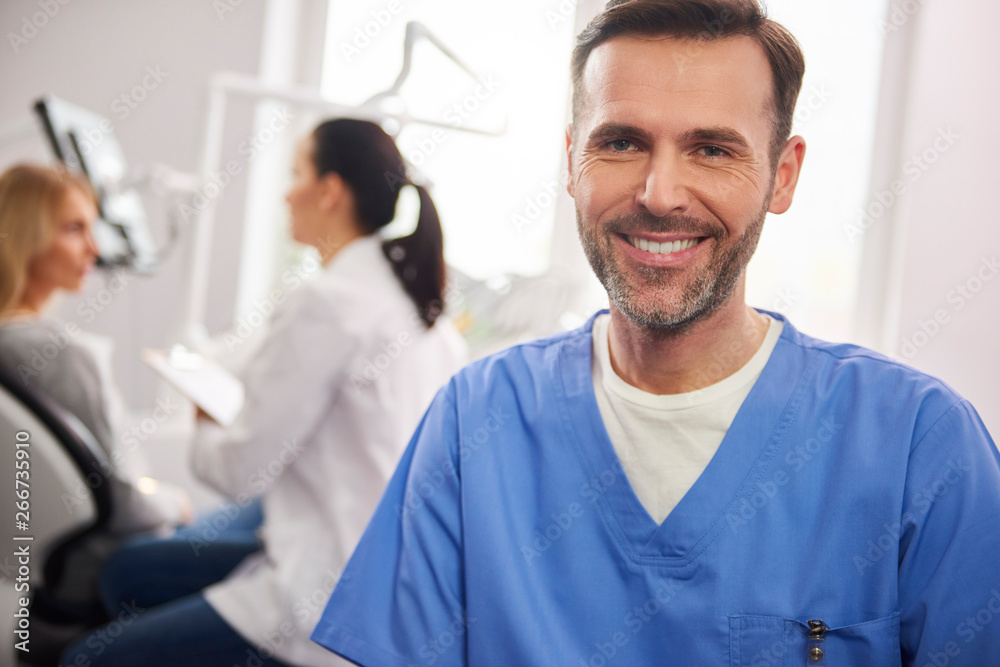 Front view of smiling male dentist in dentist's clinic Front view of smiling male dentist in dentist's clinic